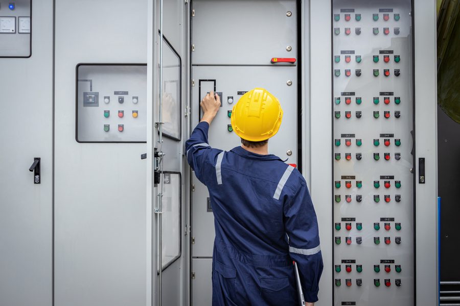 Technician inspecting electrical switchgear